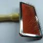 Sheepskin rug brush with a wooden handle, metal frame, and orange wire bristle pad.