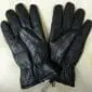 A pair of black sheepskin leather gloves with elasticated wrists and visible stitching.