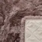 Close-up of a mauve rectangular sheepskin rug showing thick wool pile and a quilted non-slip backing.