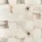 Close-up of a patchwork rug made from square shorn Icelandic sheepskin pieces in cream, grey and tan tones.