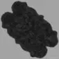 Large quad-shaped black sheepskin rug with a thick, textured wool pile and natural irregular edges.