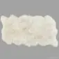 Large rectangular cream sheepskin rug with natural scalloped edges and thick wool pile.