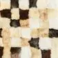 Patchwork sheepskin rug featuring a chequered pattern of white, cream, tan, and dark brown textured squares.