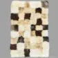 Rectangular patchwork sheepskin rug featuring a grid of cream, tan, and dark brown fur squares.