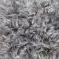 Close-up of a grey Icelandic sheepskin rug showing long, thick, textured wool fibres.
