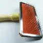 Sheepskin-Rug-Brush-061-1.jpg Sheepskin rug brush with a light wooden handle, metal frame, and orange pad with wire bristles.