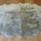 Large vole grey sheepskin rug with a natural scalloped edge and thick, textured wool pile.