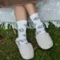 Slippers beige and white socks2 Beige merino wool slippers worn with white patterned socks.