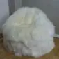 Ivory sheepskin bean bag with long, fluffy wool texture.