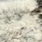 Rug-083a Close up of a long-pile Icelandic sheepskin rug in shades of light grey, cream and charcoal.