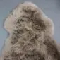 SHEEPSKIN RUG NZS-Taupe (4) Taupe sheepskin rug with thick, curly wool and a natural pelt shape.