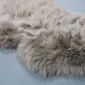 SHEEPSKIN RUG NZS-Taupe (6) Close-up of a taupe sheepskin rug with long, thick wool fibres.