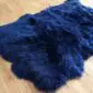 Large navy blue sheepskin rug with a thick, textured wool pile and natural curved edges.