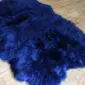 Large navy blue sheepskin rug with thick, long wool pile and natural curved edges.