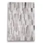 Rectangular patchwork cowhide rug featuring vertical silver, grey and charcoal stripes.