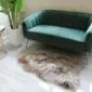 Long-haired taupe Icelandic sheepskin rug with natural irregular edges on a light floor.