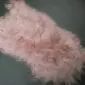 Long-haired pale pink Icelandic sheepskin rug with a natural shape and shaggy texture.