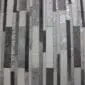 Patchwork cowhide rug featuring vertical stripes in varying shades of silver, grey, and charcoal.
