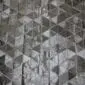 Patchwork cowhide rug featuring a geometric pyramid pattern in shades of black, grey, and white.
