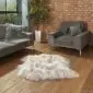 A long-haired, cream-coloured Icelandic sheepskin rug with two joined skins on a wooden floor.