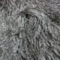 Close-up of a grey Mongolian lambskin rug with long, curly wool fibres.