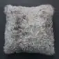 Square Tibetan sheepskin cushion with long, curly grey and white wool fibres.