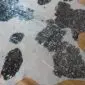 Close-up of a black and white cowhide rug with silver metallic splatters.