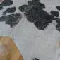Natural cowhide rug with black patches on a white base and silver metallic splatters.