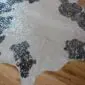 Black and White Silver Metallic Cowhide Rug CM226b Natural-shaped white cowhide rug with black spots and metallic silver speckles on a wooden floor.