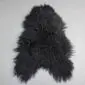 Black Icelandic sheepskin rug with a natural curly texture and irregular organic shape.