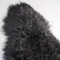 Natural black Icelandic sheepskin rug with long, curly wool fibres.