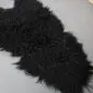 Natural black Icelandic sheepskin rug with long, curly wool fibres and an irregular organic shape.