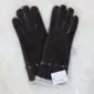 Dark brown suede sheepskin gloves with long cuffs, visible stitching, and cream wool lining at the wrists.