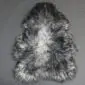 Natural grey curly sheepskin rug with a textured, woolly surface and organic shape.