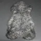 Natural grey curly sheepskin rug with a textured, woolly surface and organic pelt shape.