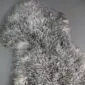 Natural grey sheepskin rug with a thick, curly wool texture and irregular organic shape.