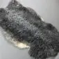 Natural grey Gotland sheepskin rug with curly wool and cream edges.