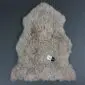 Beige curly sheepskin rug with a natural pelt shape and textured wool pile.