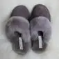 A pair of mink grey sheepskin slippers with fluffy collars and suede uppers.