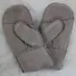 A pair of beige sheepskin mittens with visible stitching and folded cuffs on a white textured surface.
