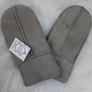 A pair of grey sheepskin mittens with visible stitching and folded cuffs.