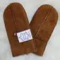 A pair of tan sheepskin mittens with visible stitching and a white product tag.