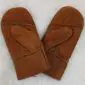 A pair of tan sheepskin mittens with visible stitching and a soft suede exterior.