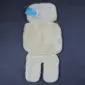 Cream sheepskin stroller liner with a soft wool texture and a blue brand tag on a dark background.
