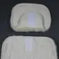Cream sheepskin stroller liner with a padded headrest and fabric backing .