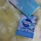IMG_8331 Cream-coloured, short-pile washable baby lambskin rug with two blue product information booklets.
