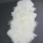 Long ivory Mongolian lambskin rug with curly wool texture on a dark grey background.
