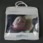 Baby sheepskin stroller liner in a clear plastic carry bag with white handles and a branded insert.