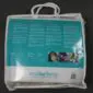 Sheepskin stroller liner inside a clear plastic carry bag with a teal and white product information label.