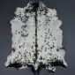 Natural goatskin rug with white fur, black spots, and a dark central stripe.